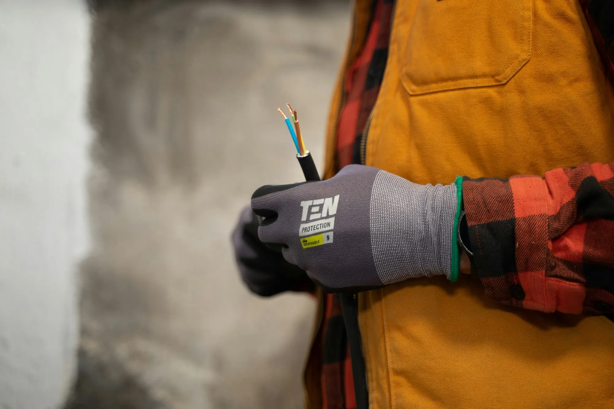 Electrician holding stripped cable conductors
