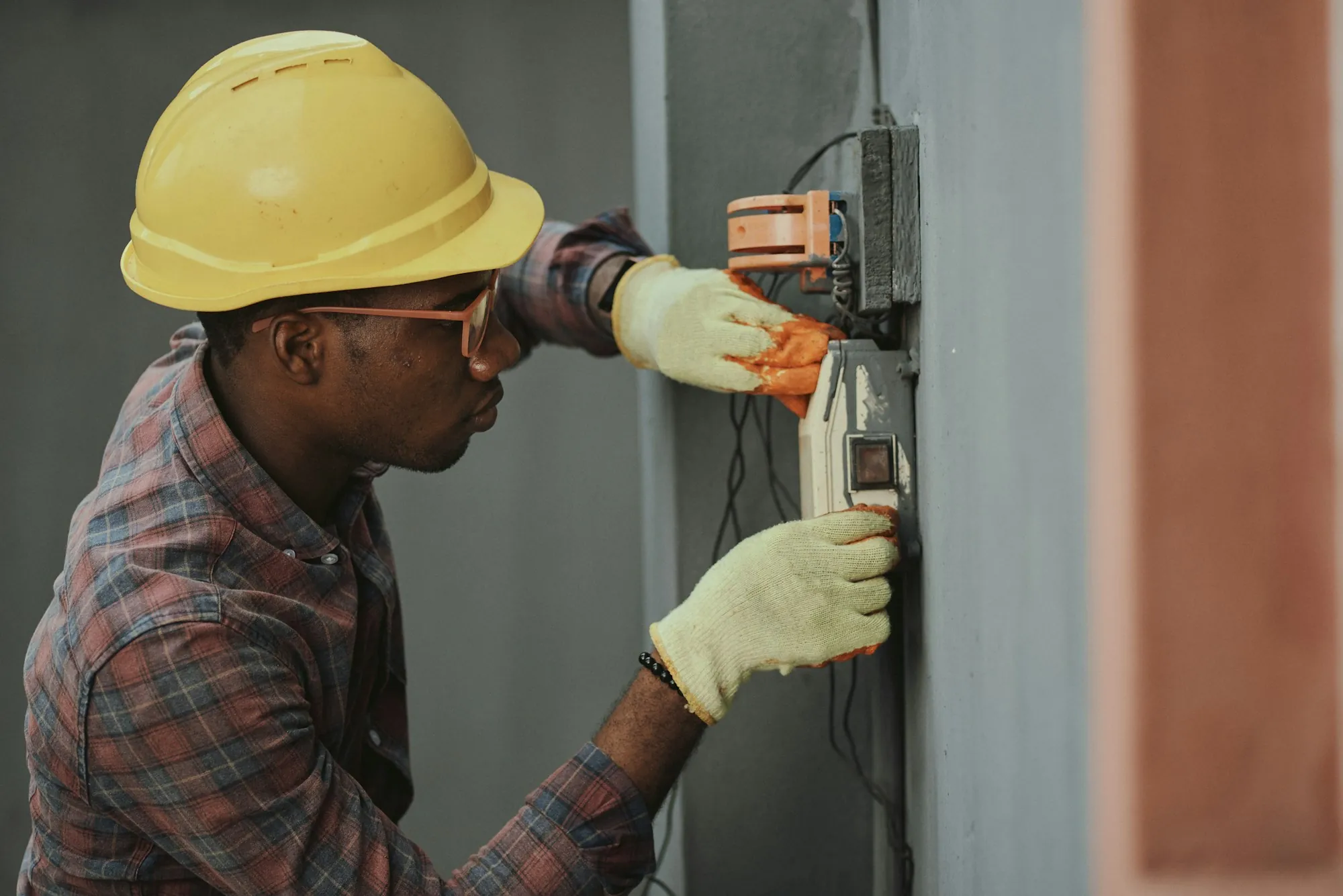 Electrician using a screwdriver on an electrical panel